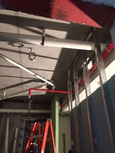 Montaje de cañerías en cielo de edificio